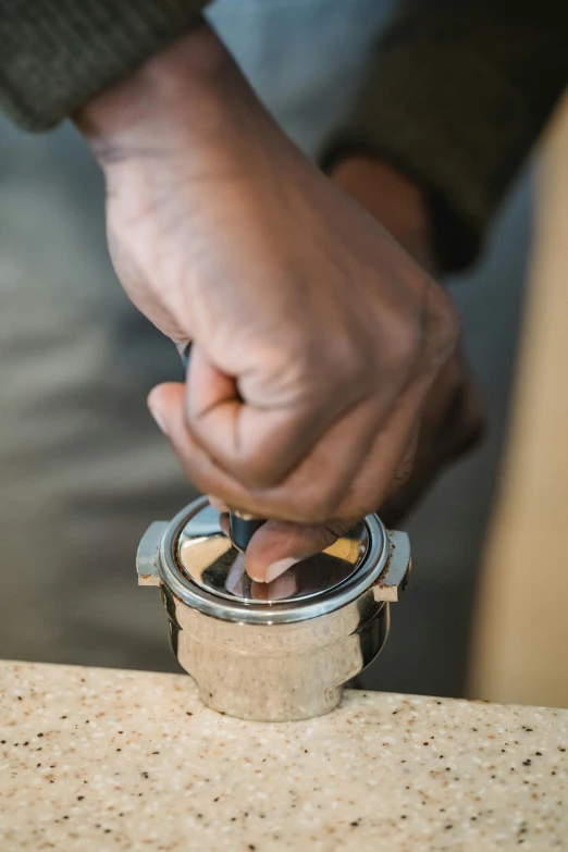 man's hands are sticking peanuts into a container