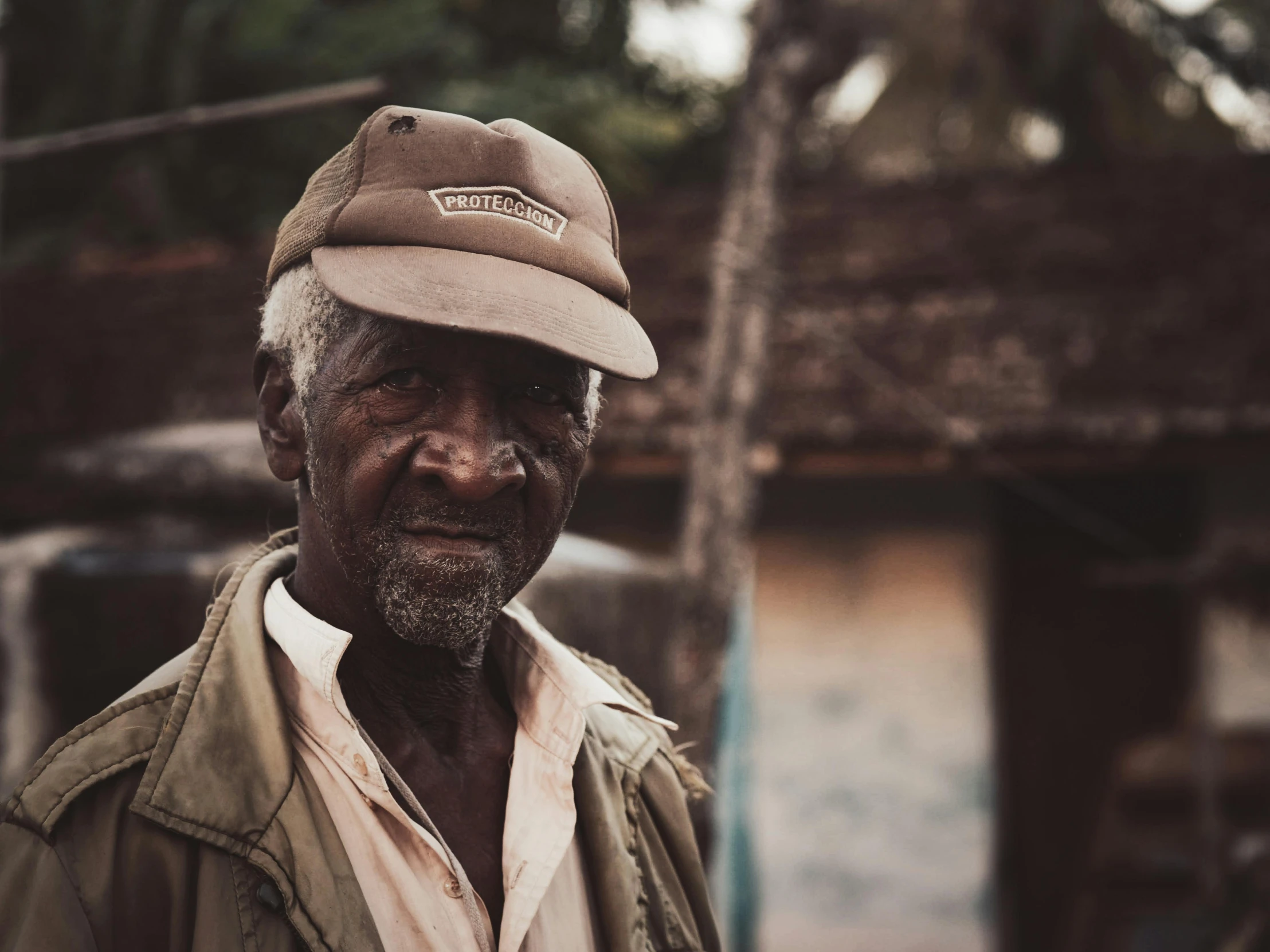 an older man is in a hat with mud on his face