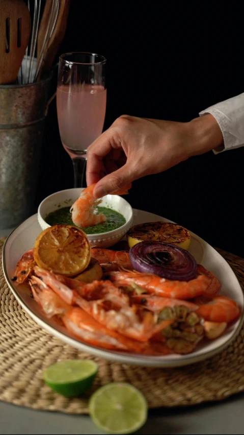 a plate with shrimp, steaks and chips with a wine glass