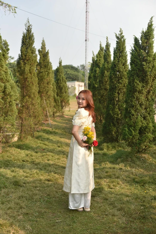 an asian woman wearing a white dress in the field