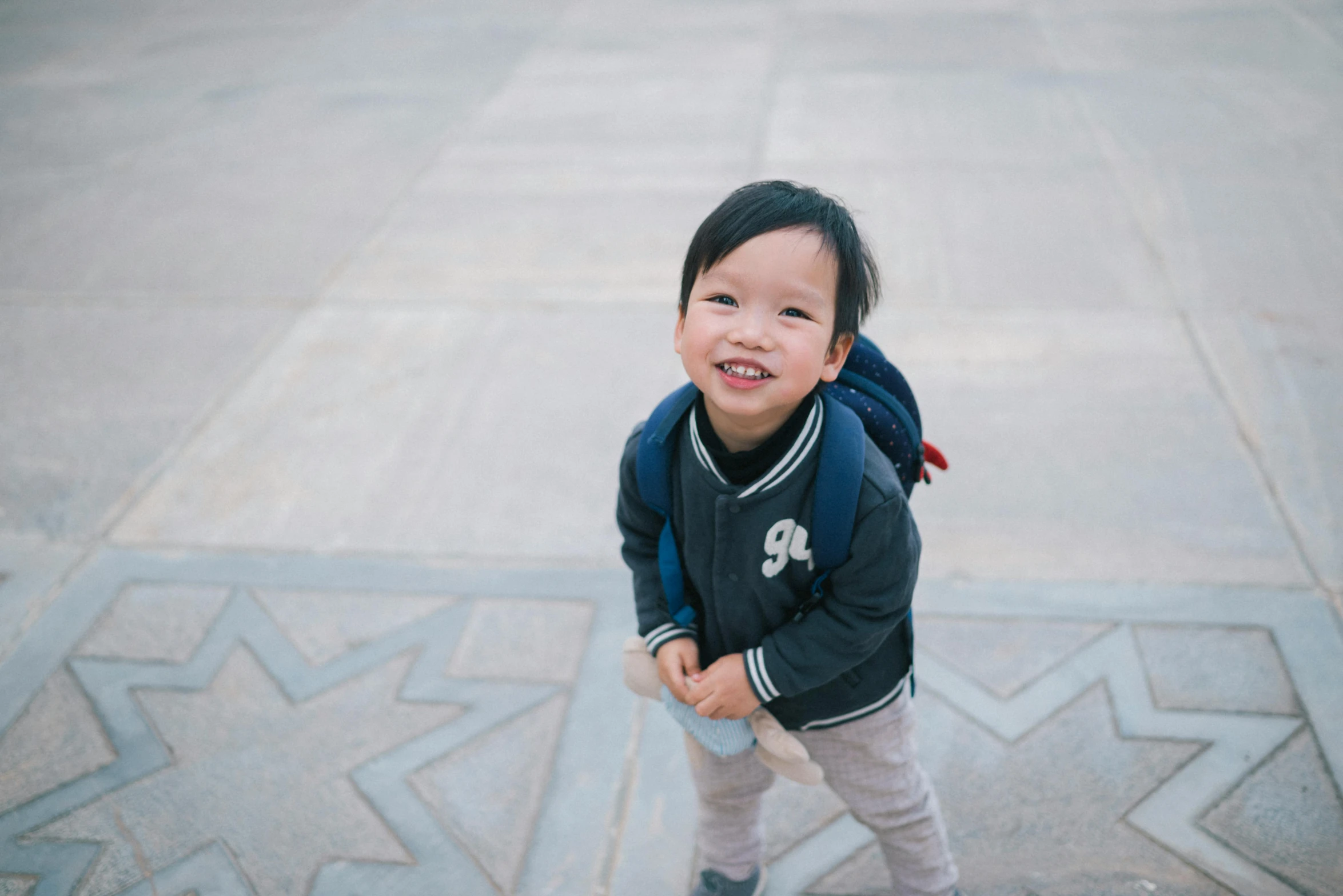 a child wearing a blue backpack standing near star walk