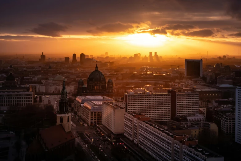 a sunset in the cityscape from a tall building