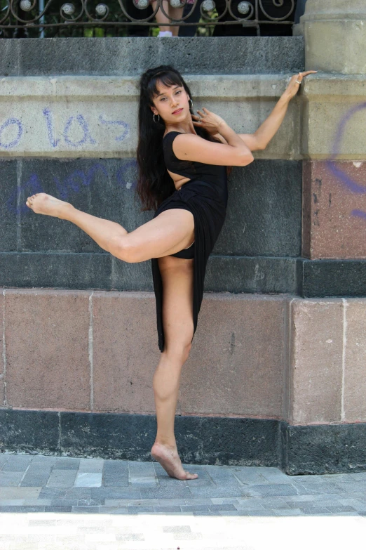 a woman in tight underwear and black heels with her  and one leg on the ground