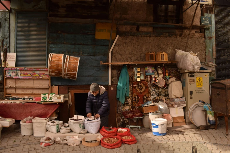 woman standing in front of a small shop selling household items