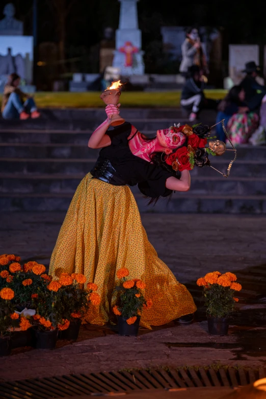 a woman in yellow skirt holding an lit candle