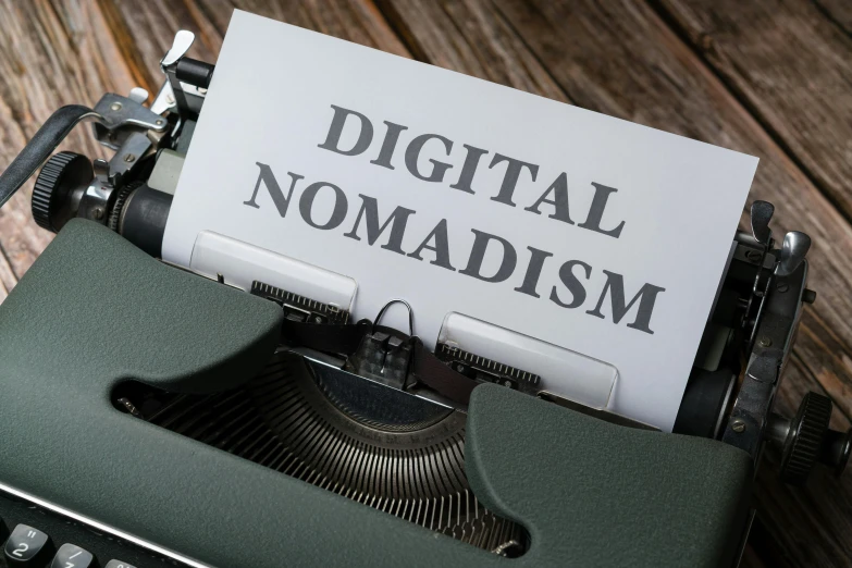 a paper on an old fashioned typewriter reads digital nomadism
