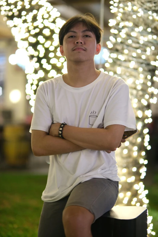 a young man in a white shirt is posing for the camera