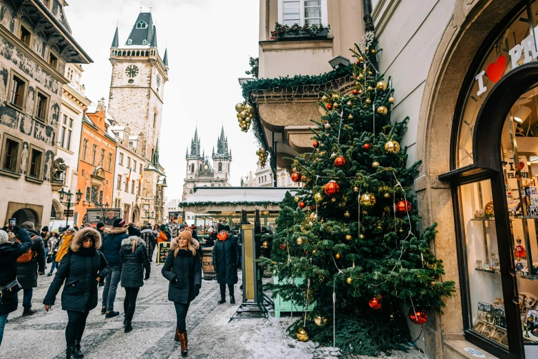 people are walking around near a christmas tree