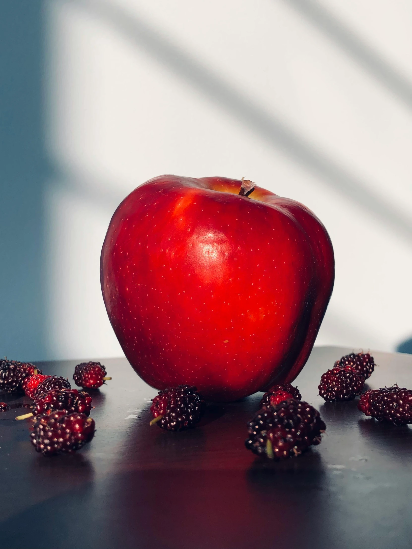 a red apple that is next to some berries