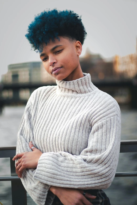 a young woman in an oversized white sweater is posing