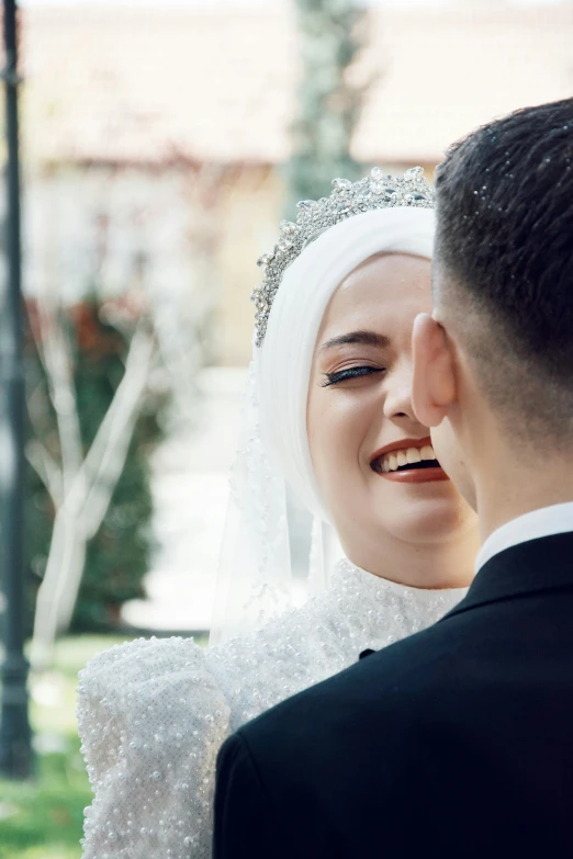 a man and woman in wedding attire stand by a lamp