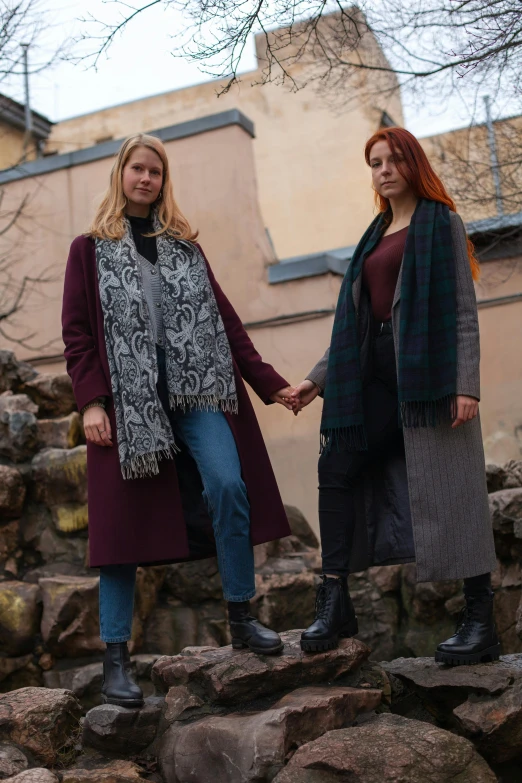 two women standing together in front of a large building