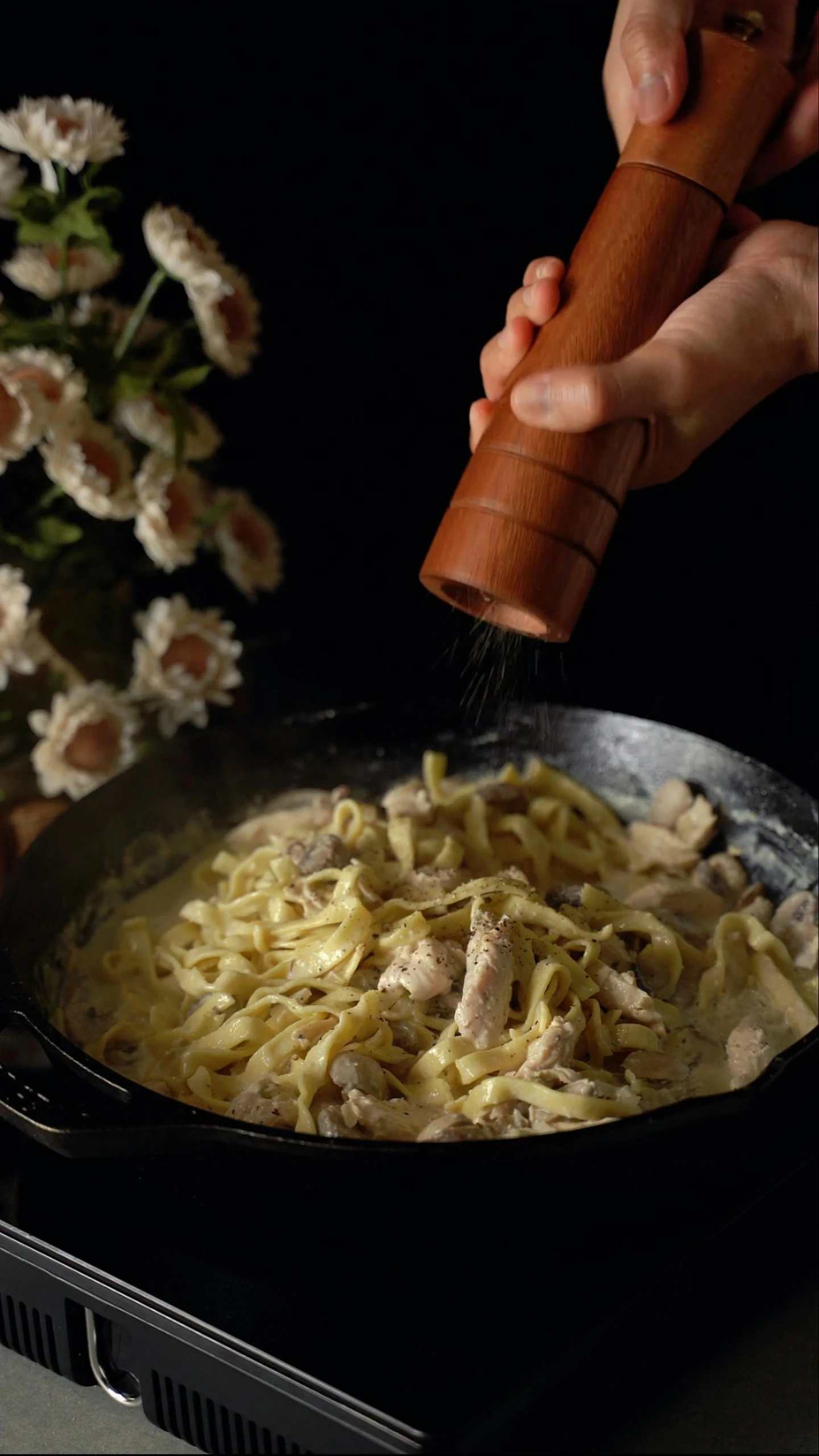 pasta being sprinkled with parmesan cheese in a set