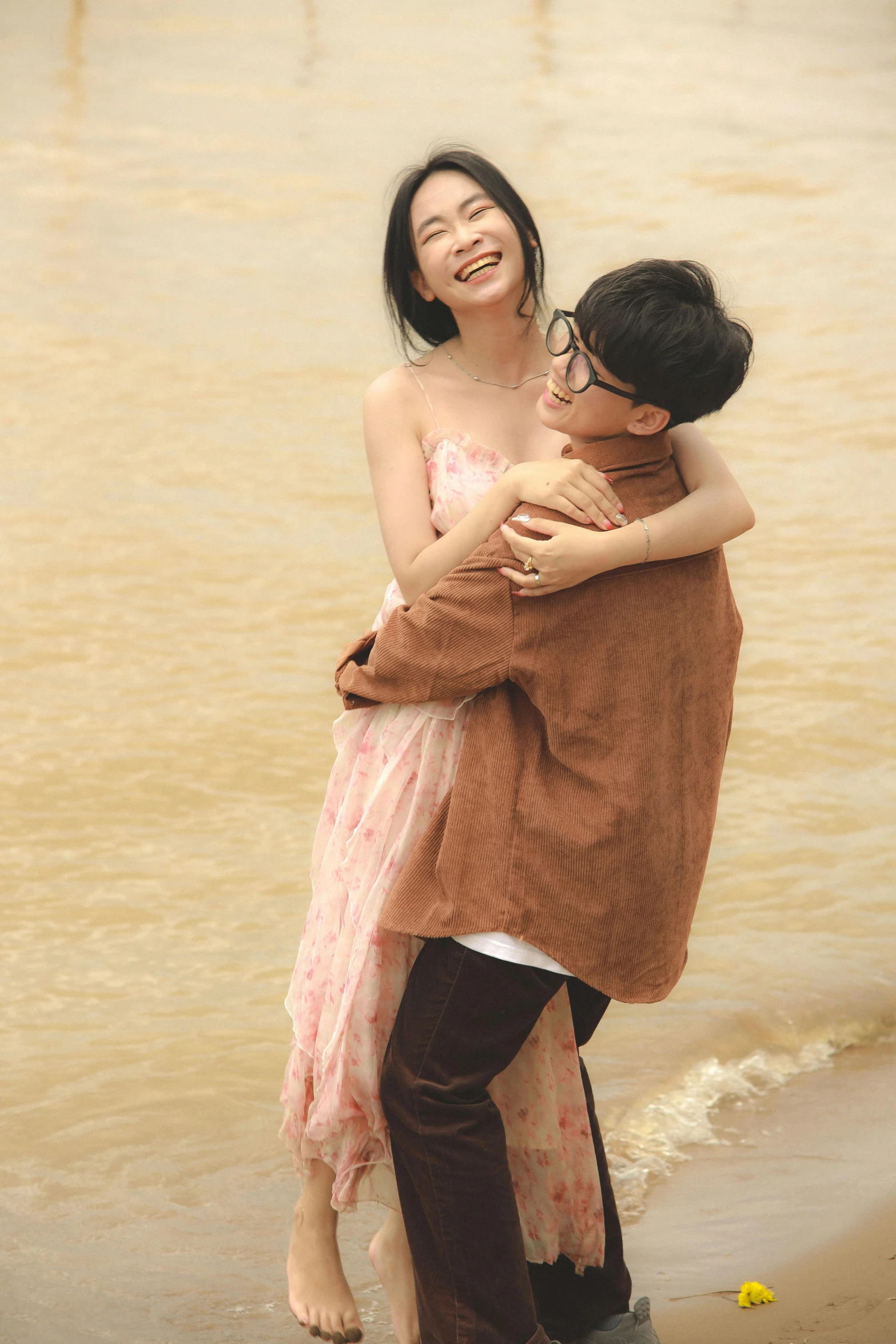 an asian couple in love emcing on the beach