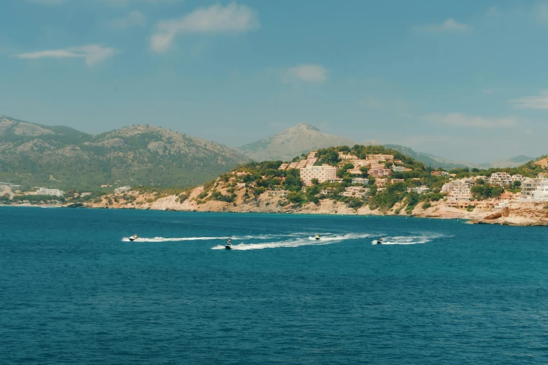 a speed boat traveling across the water in front of mountains