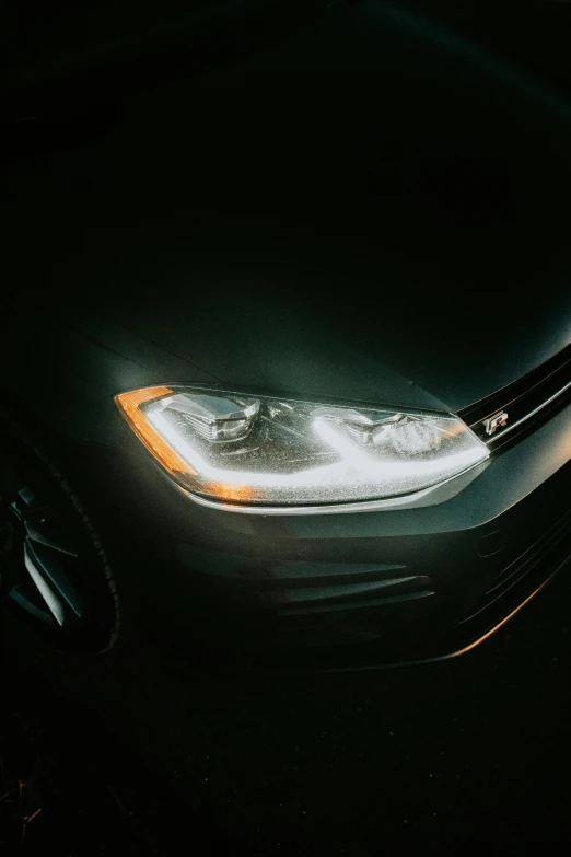 a close up image of the headlight of a car in dark light