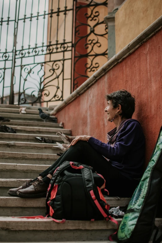 a man sitting on steps with some luggage