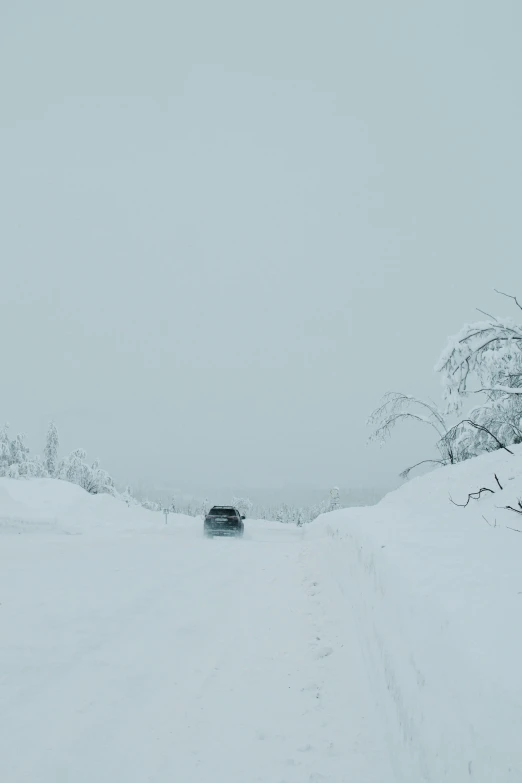 the snow covered road has cars on it