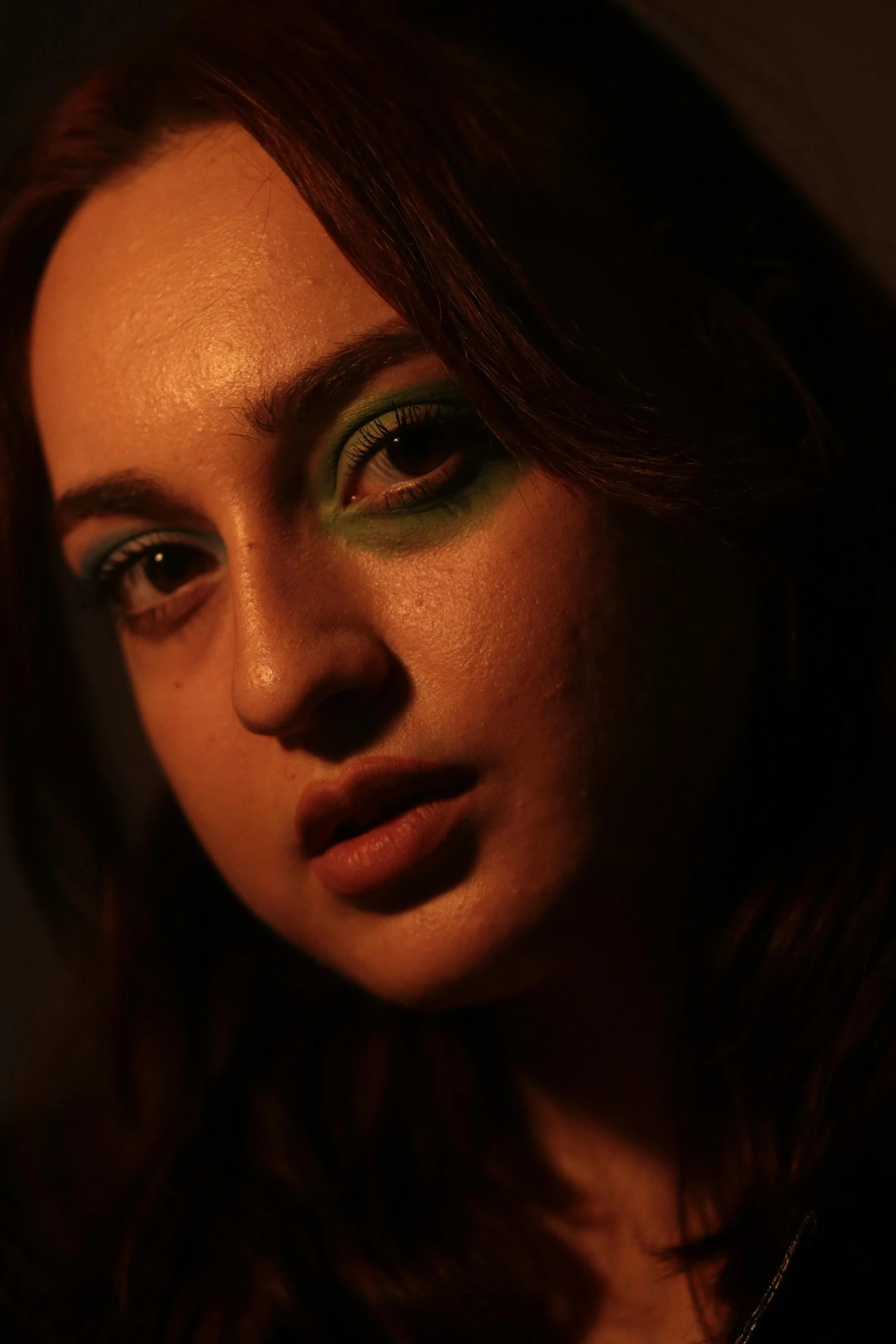 a woman in profile with green makeup