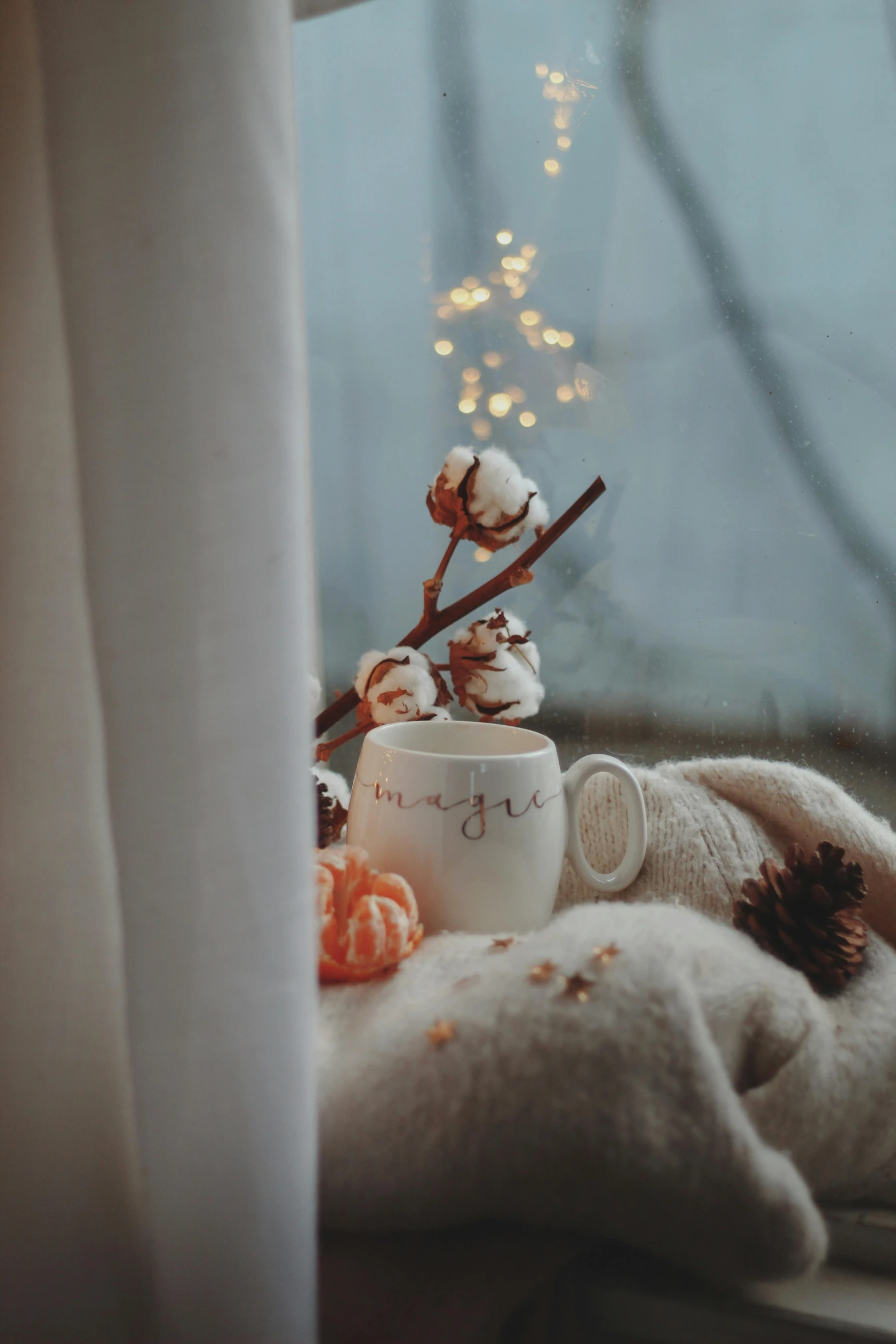 a pile of cotton balls and a cup on a windowsill