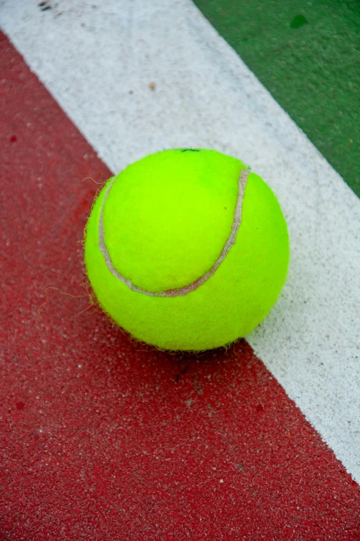 a tennis ball laying on top of a tennis court