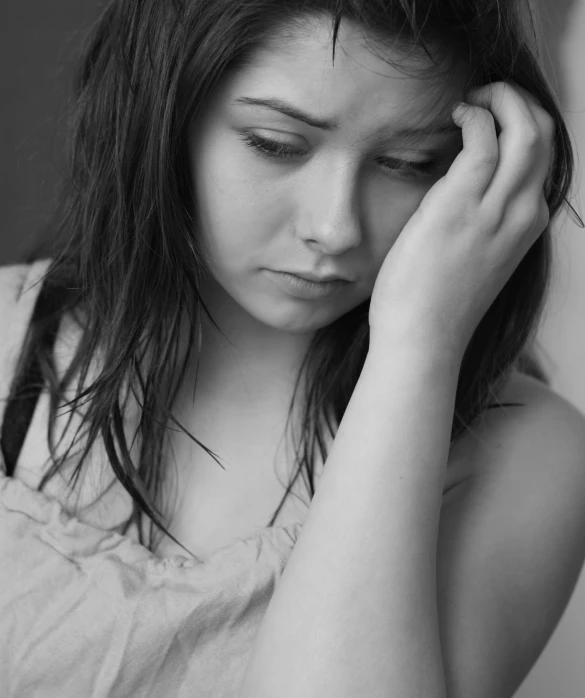 black and white image of a girl with her hand on her ear