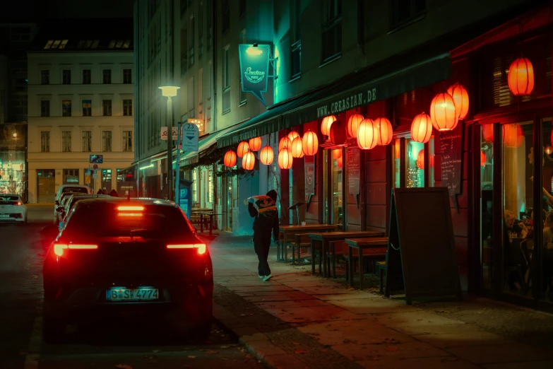 a person standing outside of a restaurant with red lanterns