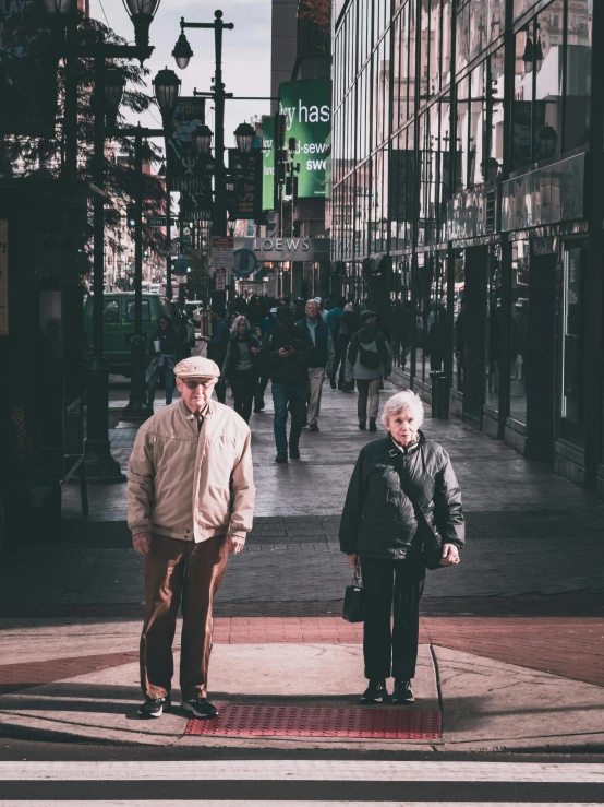 two people are walking down the sidewalk near some people