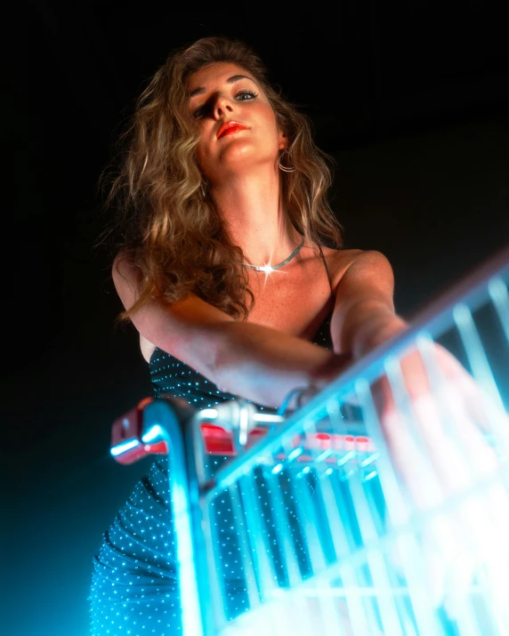 a beautiful woman standing in a cage with her arm over a railing