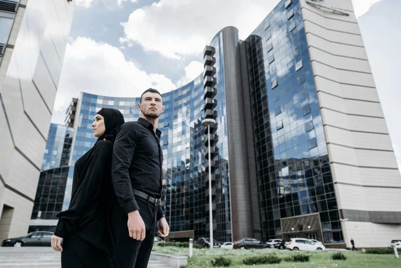 a man and woman walking together down the street in front of some large building