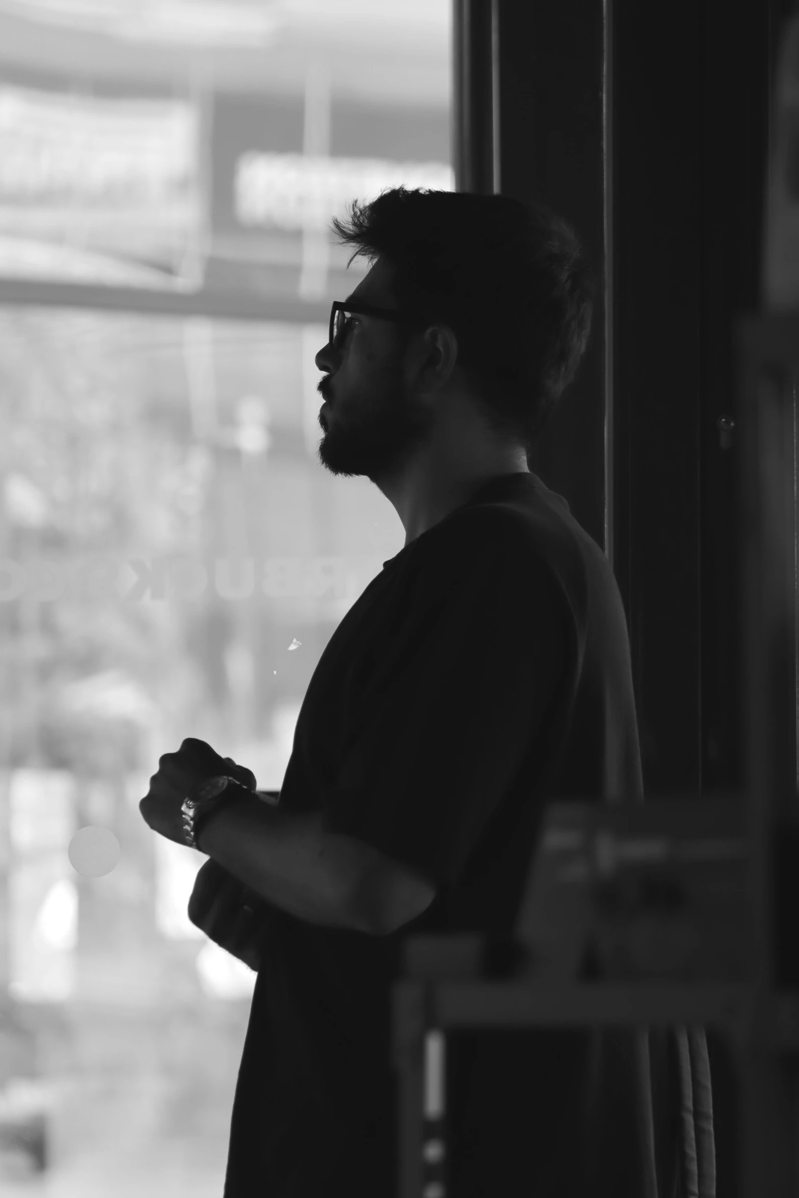 a man in black and white is looking out of a window