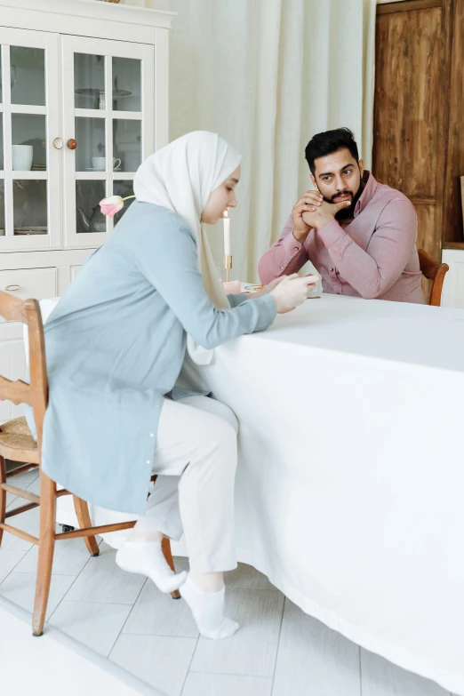 the woman and the man are sitting down to a meal