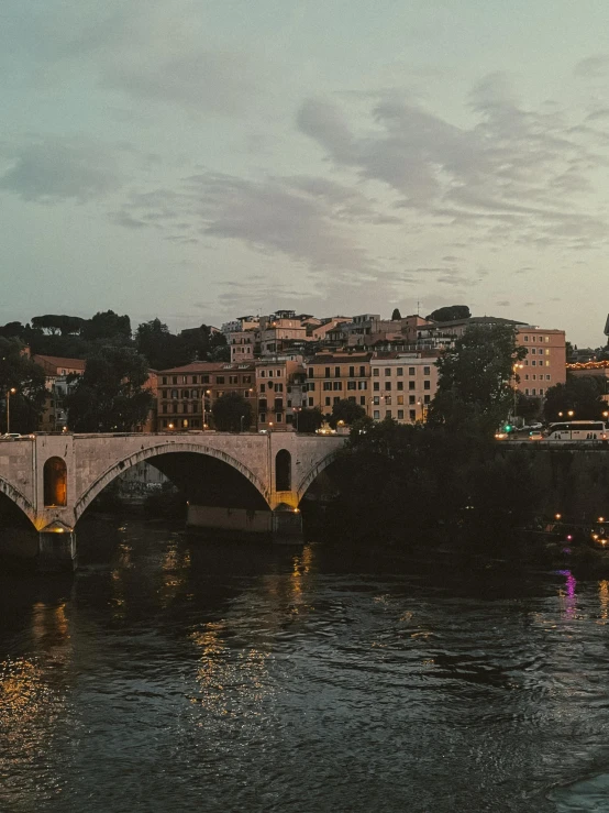 a bridge with a river under it in front of a city