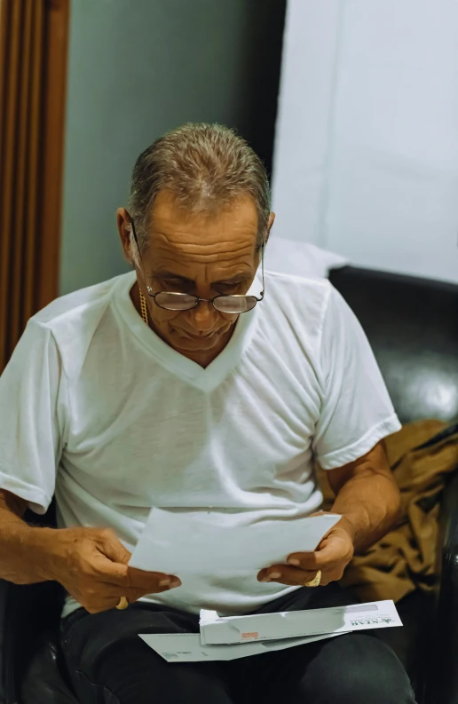 a man sitting in a chair with paper and pens