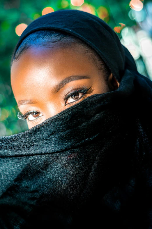 a woman wearing a black scarf looking at the camera