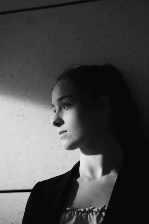 a woman in a jacket looking out a window