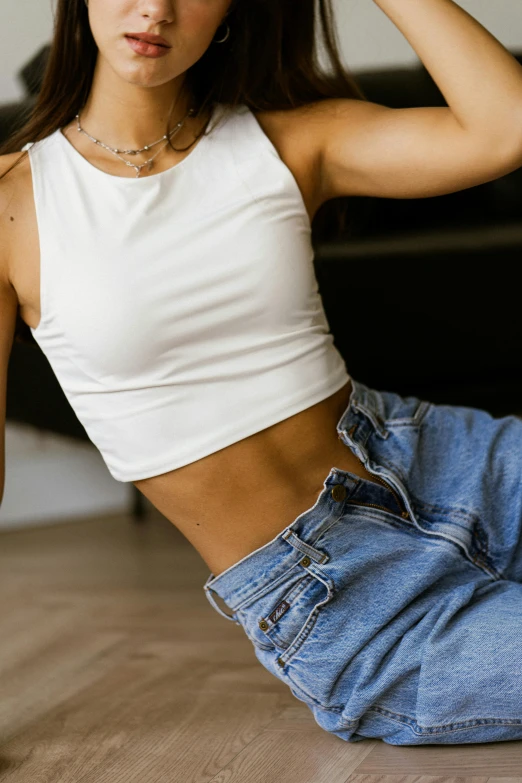 a young woman poses on the floor with her leg spread