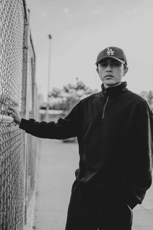 a man is standing next to a fence