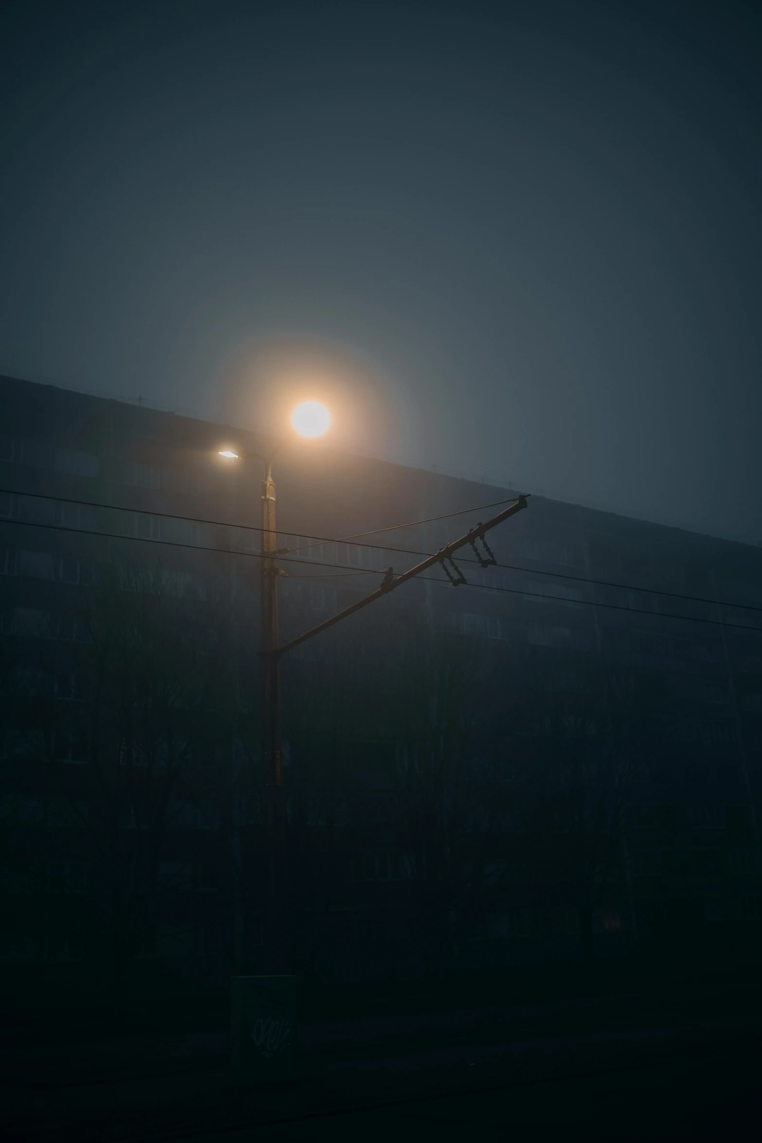 a street light in the fog with train tracks