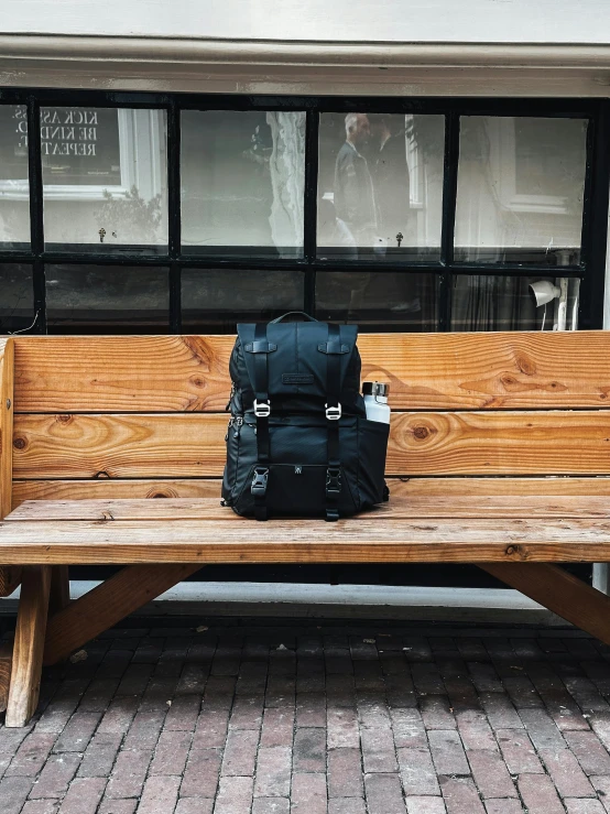 a backpack sitting on top of a wooden bench