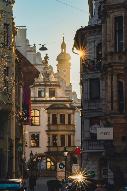 a group of people walking down a street next to buildings