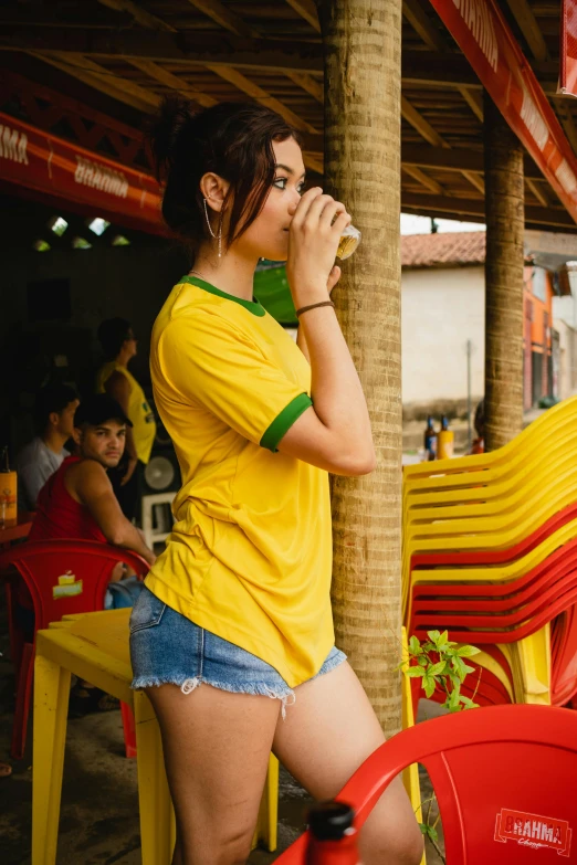 a woman standing next to a red and yellow chair