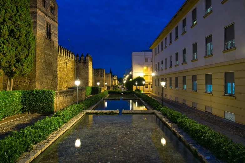 the courtyard and pond at night with lights on