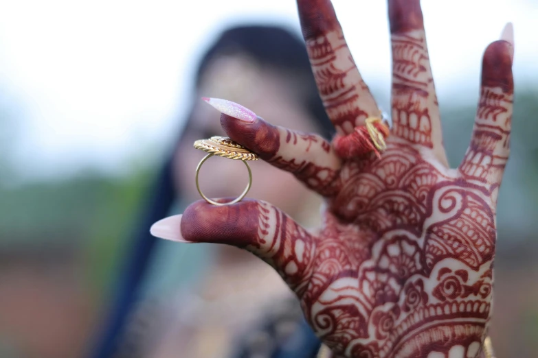 a woman is holding up her hand with an intricate pattern on it