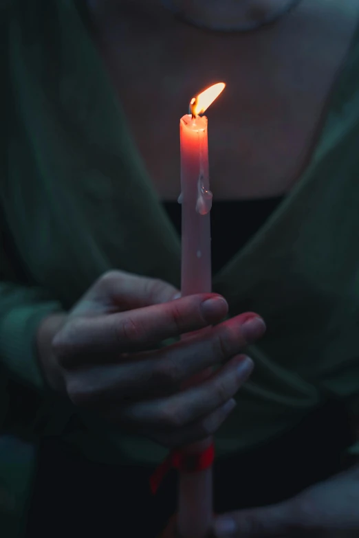 a woman is holding a lit candle in her hand