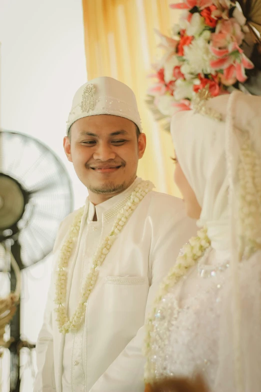 a groom is getting dressed and smiling for the po