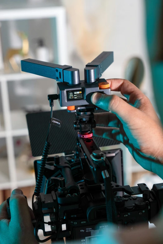 someone holding a tripod on a desk in a living room