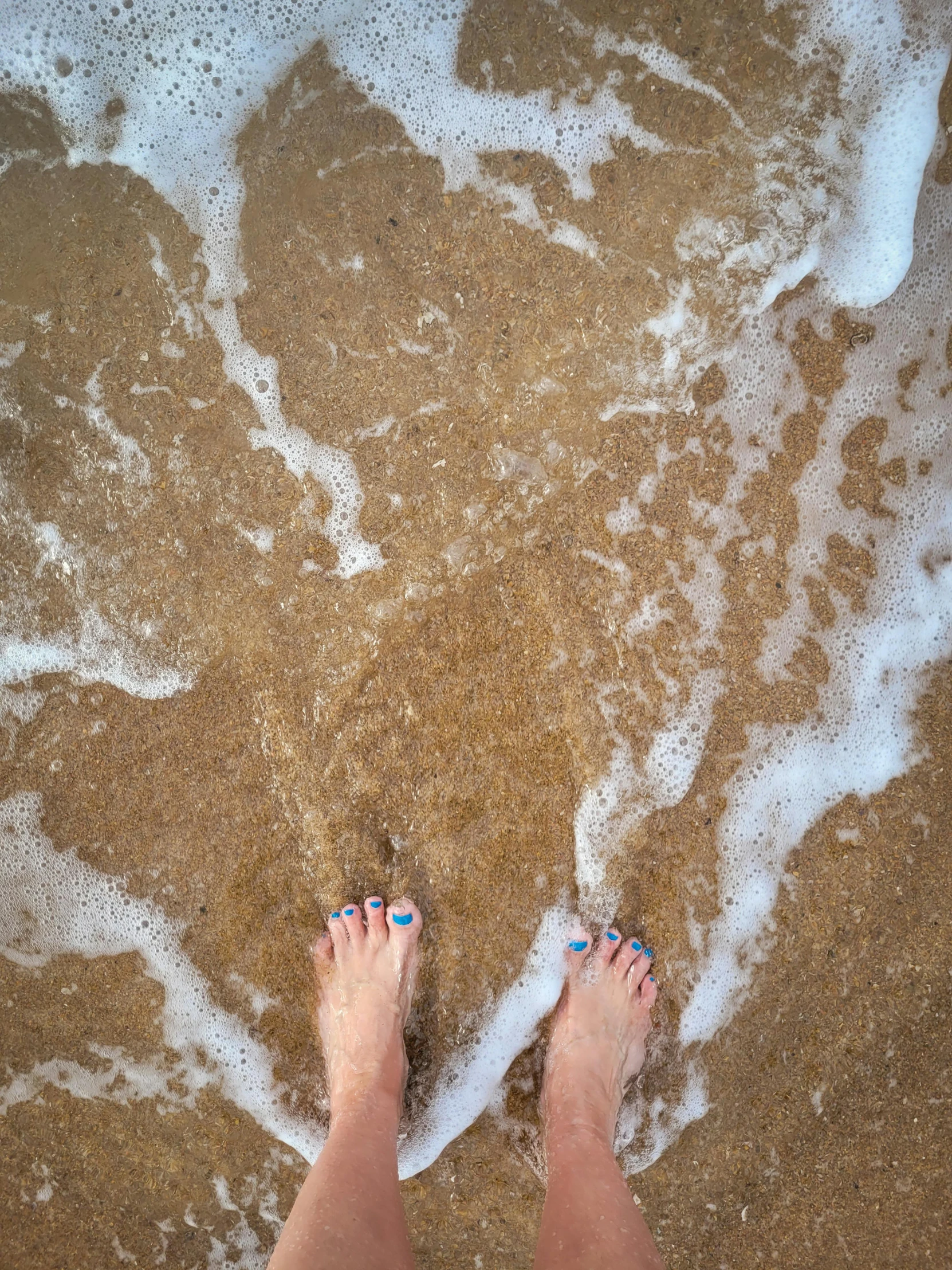 a person standing on top of the sand at the beach