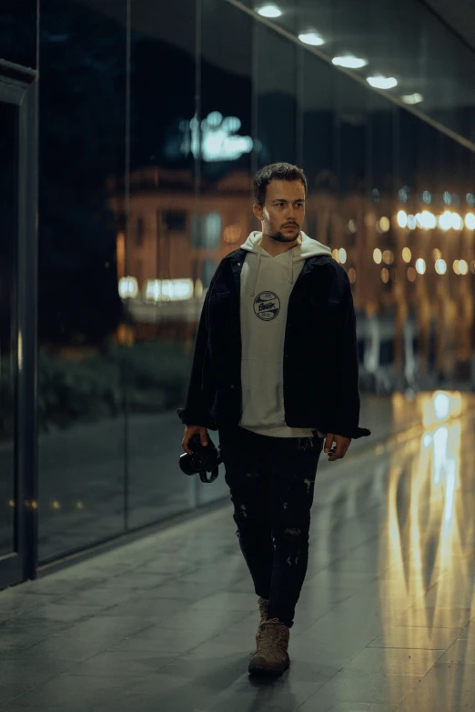 a man walking along a road wearing a jacket