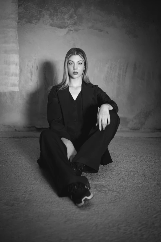 a woman sitting on the ground with her arms folded out